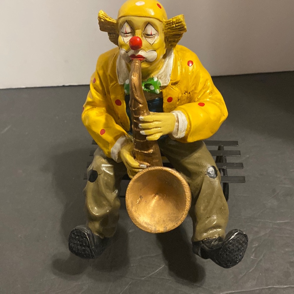 Vintage hobo clown playing the saxophone sitting on a bench ceramic 8x5”